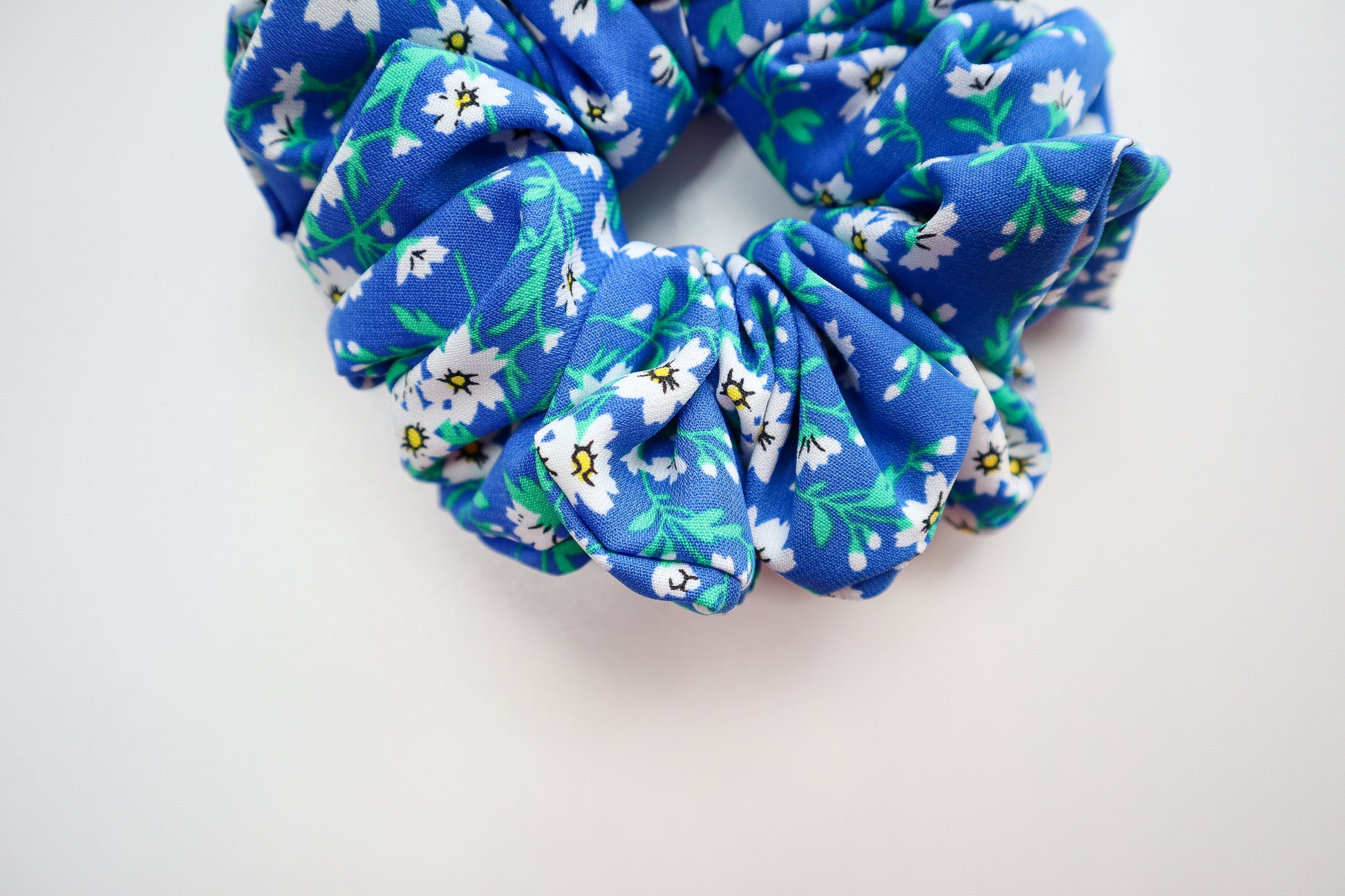 Blue floral scrunchie on a white background. This photo represents true color of the fabric.
