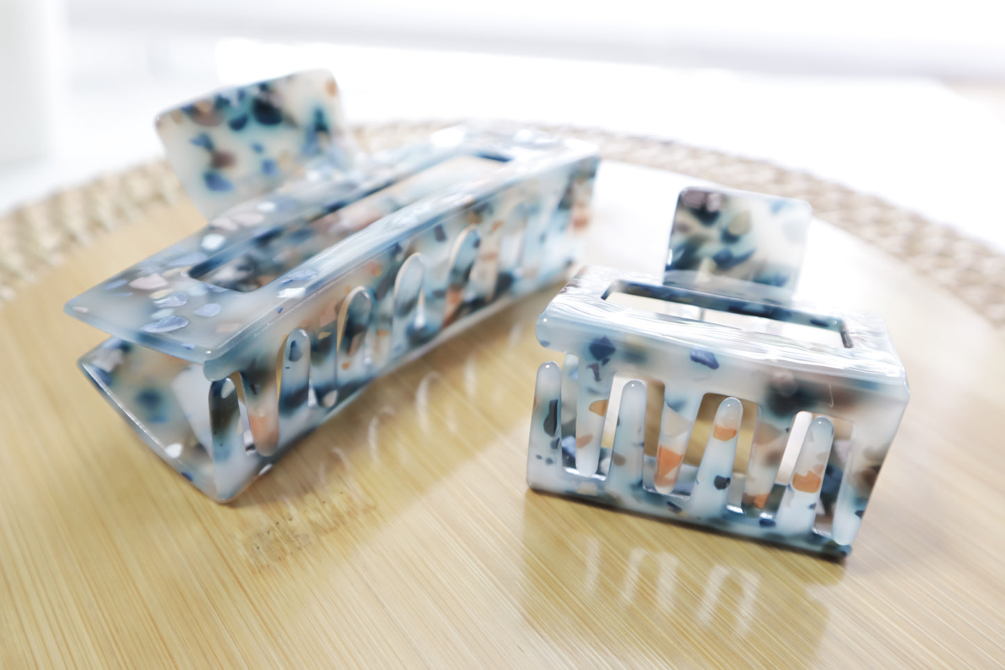 Set of two hair clips with a multicolor pattern on a wooden surface