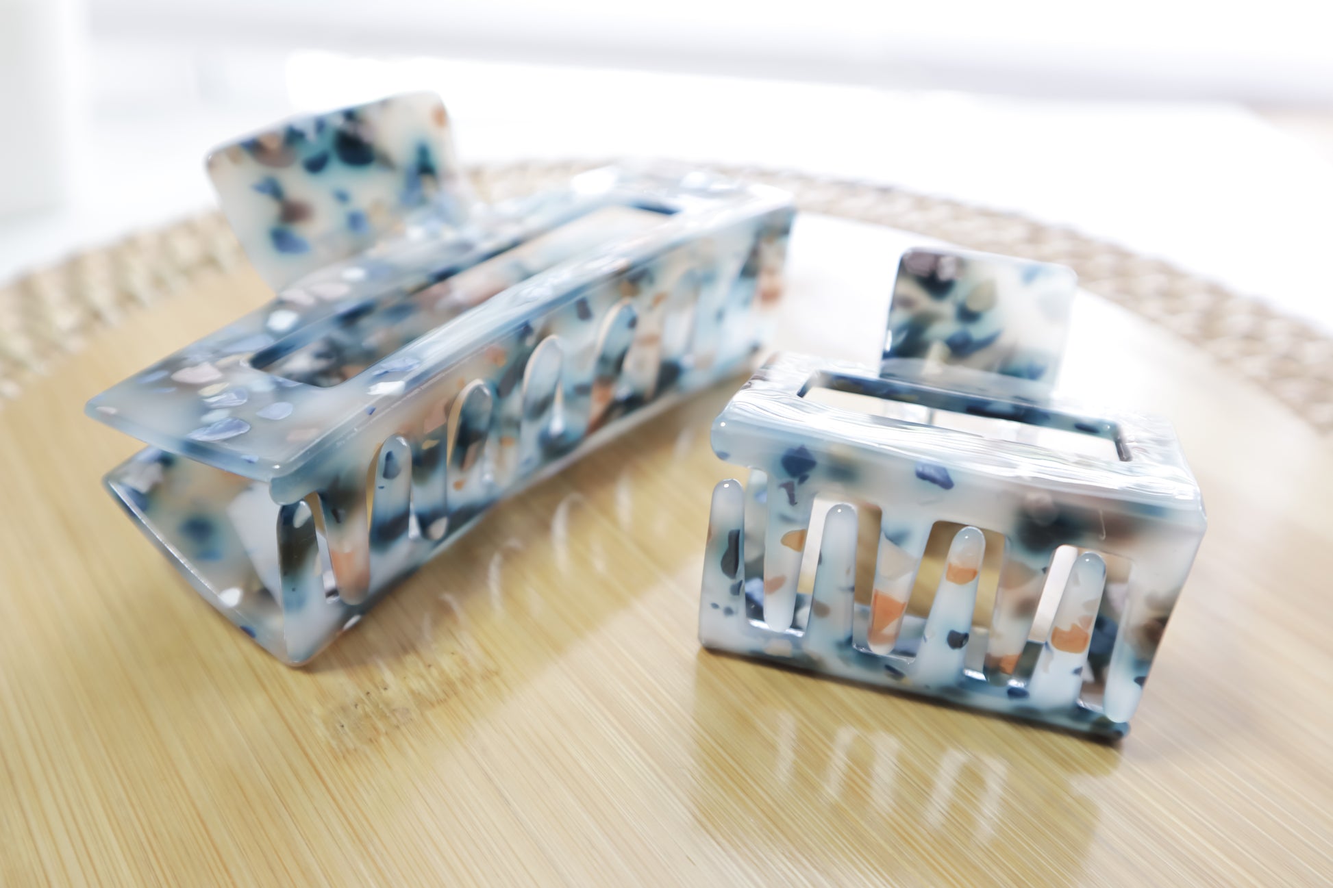 Set of two hair clips with a multicolor pattern on a wooden surface