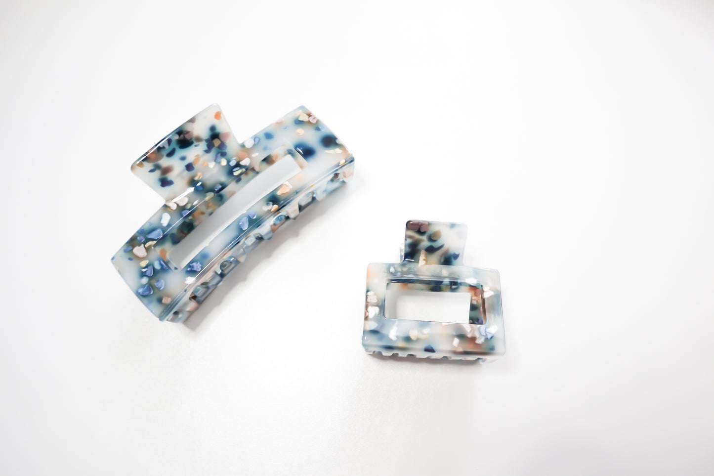 Two marbled rectangular hair clips on a white background