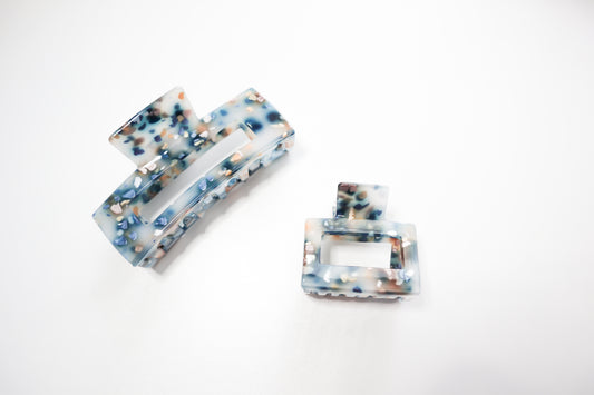 Two marbled rectangular hair clips on a white background