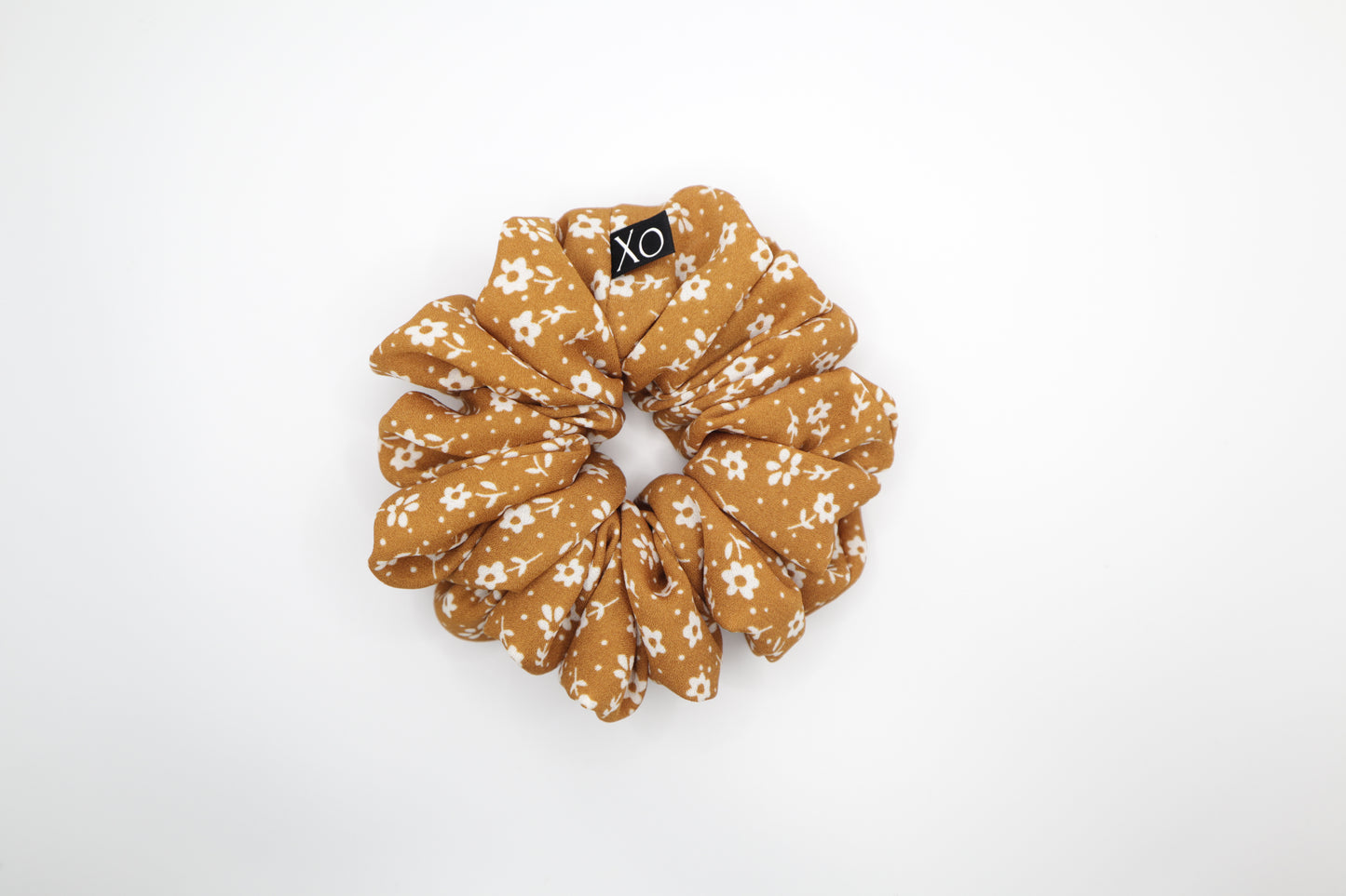 Mustard brown floral scrunchie on a white background. Photo represents the true color of fabric.