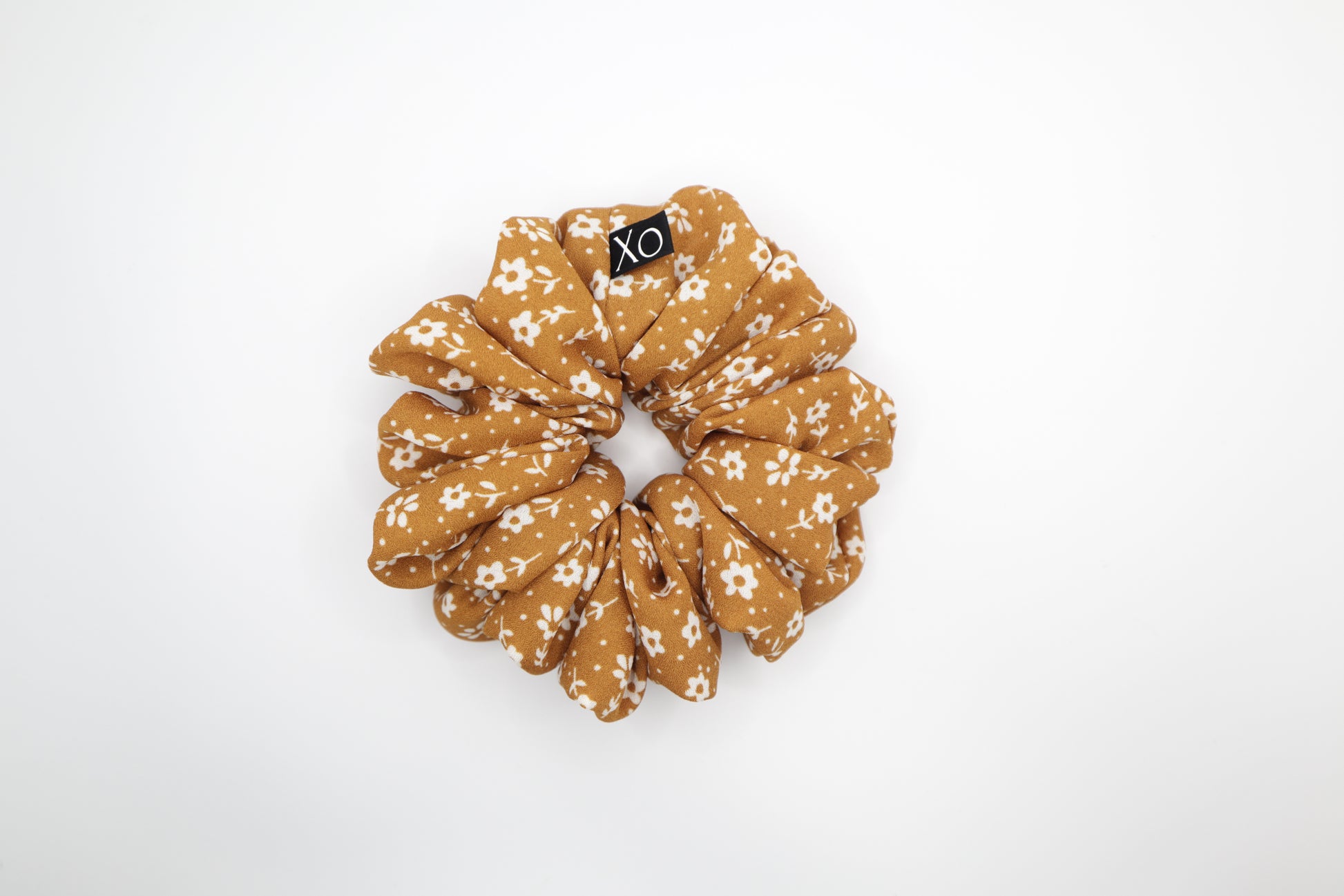 Mustard brown floral scrunchie on a white background. Photo represents the true color of fabric.