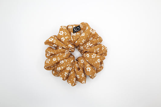 Mustard brown floral scrunchie on a white background. Photo represents the true color of fabric.