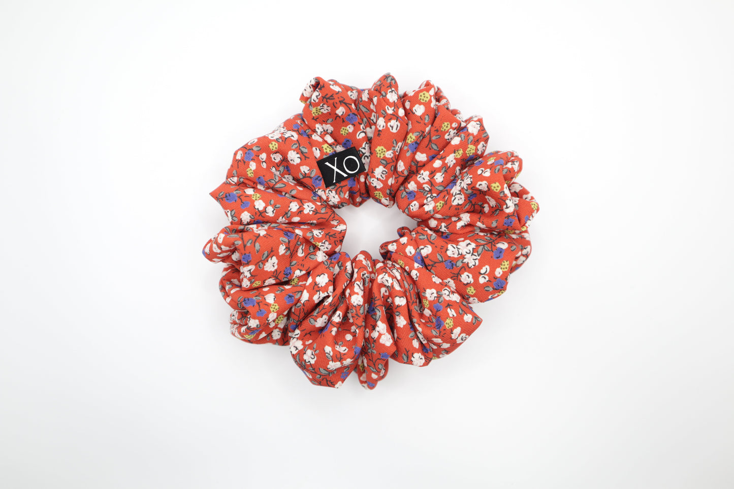 Red floral scrunchie with 'XO' logo on a white background