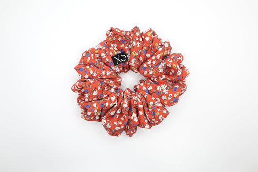 Red floral scrunchie with 'XO' logo on a white background