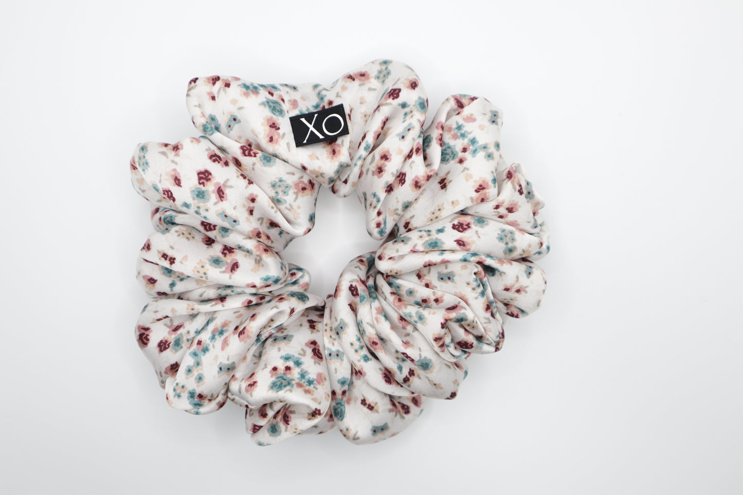 Floral patterned scrunchie with 'XO' logo on a white background