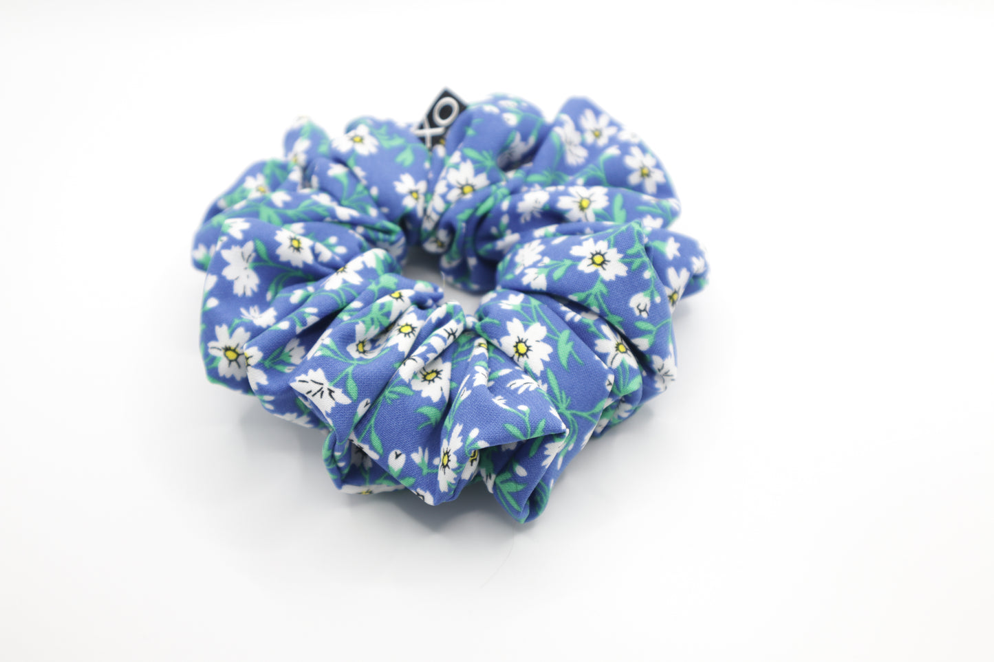 Blue floral scrunchie on a white background. Nora Scrunchie – color appears slightly lighter in this photo due to lighting. 