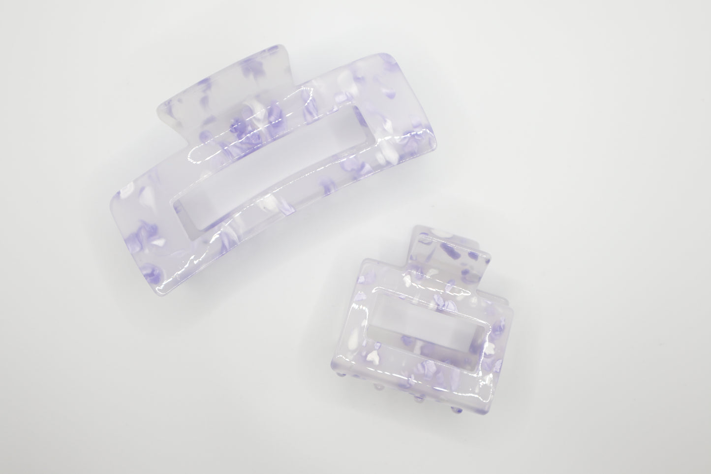Set of two clear hair clips with purple accents on a white background. Top Claw clip is 4" and bottom claw clip is 2"